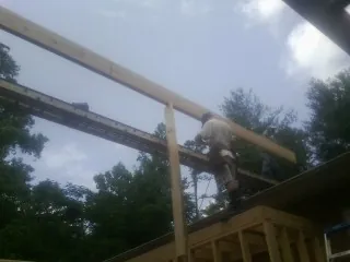 Carpenter setting a ridge beam over a new addition frame — Ice Dam Removal by Roofing Brothers in Woodhull