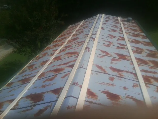 Rusted metal roof panels with new wood purlins before replacement — Storm Damage Roof Repair in Woodhull by Roofing Brothers