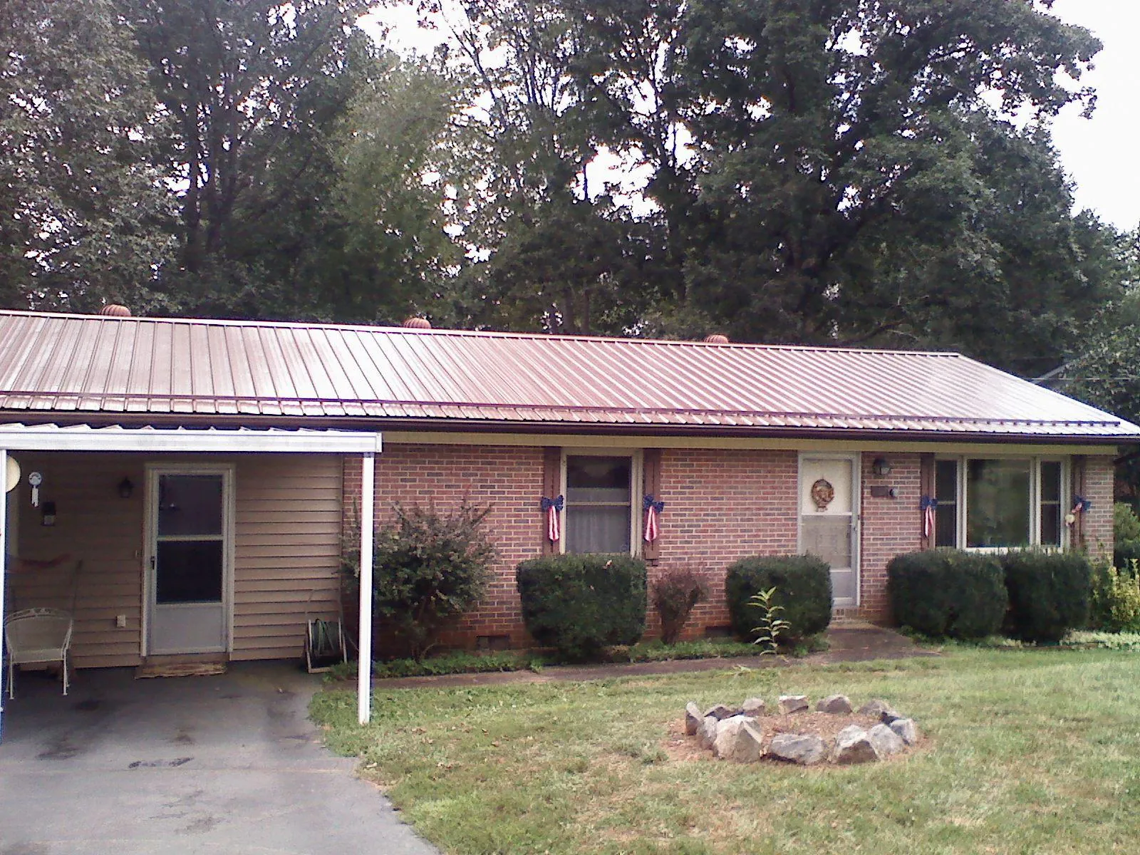 Bronze metal roof and carport on a brick ranch home — Roof Repair work by our crew in Woodhull